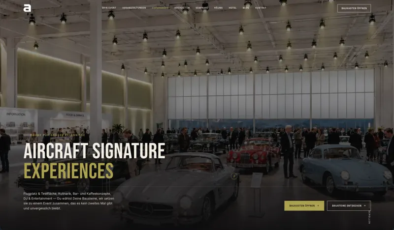 Seite „Aircraft Signature Experiences“ von aircraft events & Hotel mit Hero im Hangar mit Oldtimern